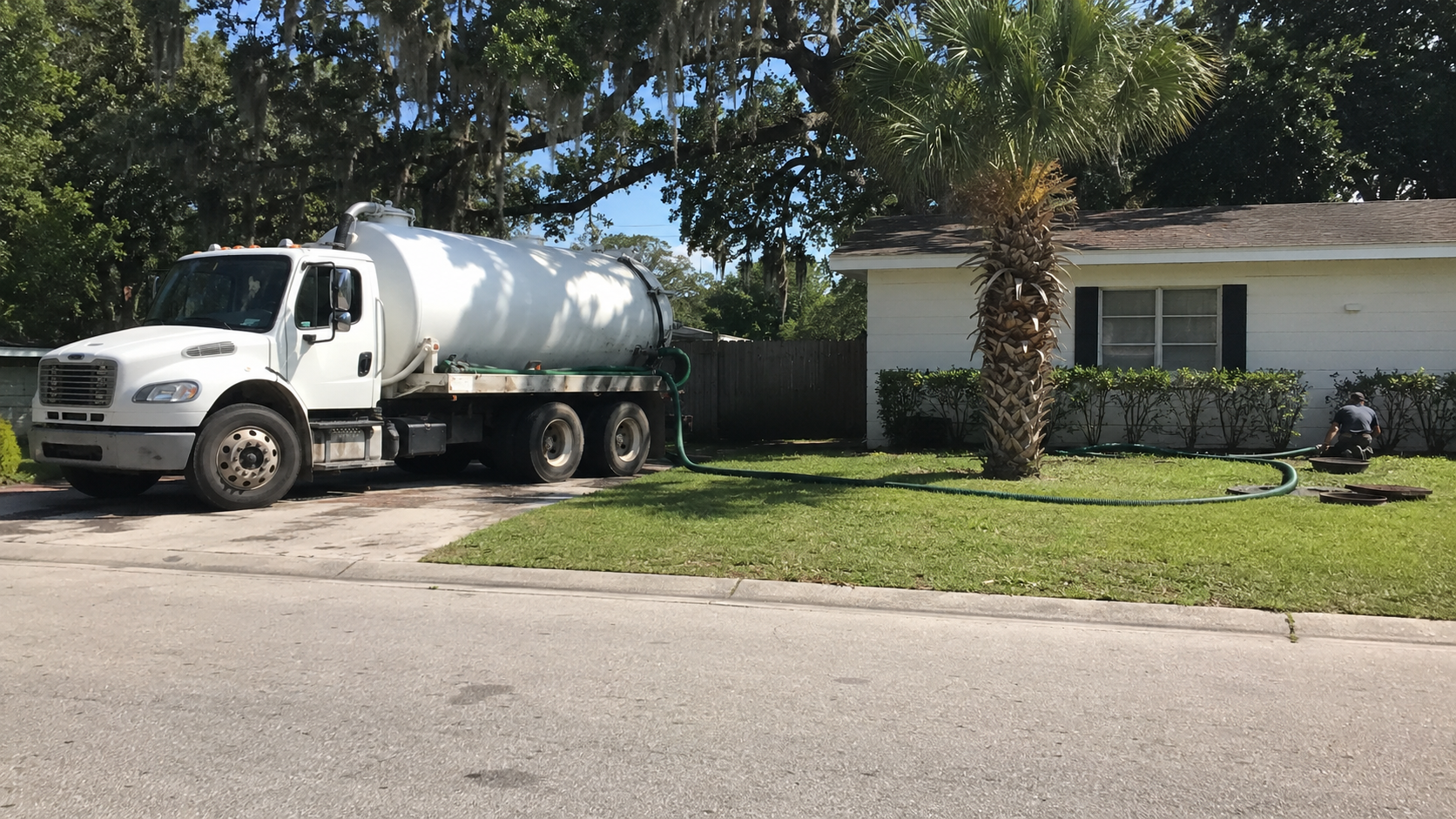 Septic pump truck parked curbside during a residential pump out